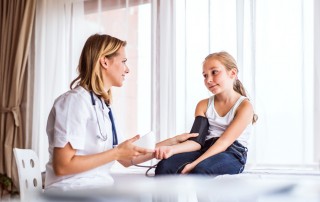 Young female doctor checking a small girl