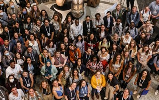 An overhead indoor image of trainees and members of the KBHN team