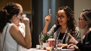 An indoor photo of a group of trainees gathered around the table socializing.