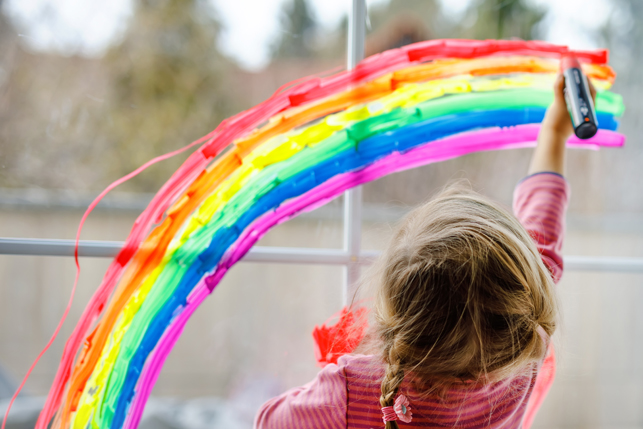 A toddler paints a rainbow.