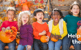 A diverse group of children are laughing and shouting while holding pumpkins. There is a text overlay that says "Helping all kids live their best lives."